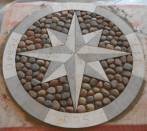 Rose of winds:travertine and pebbles.